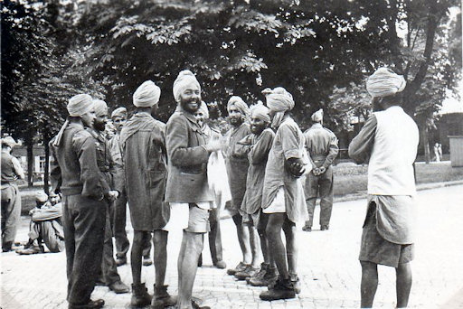 A Sikh soldier from the Legion (second from the left) speaks to a group of prisoners-of-war in an attempt to persuade them to join him.